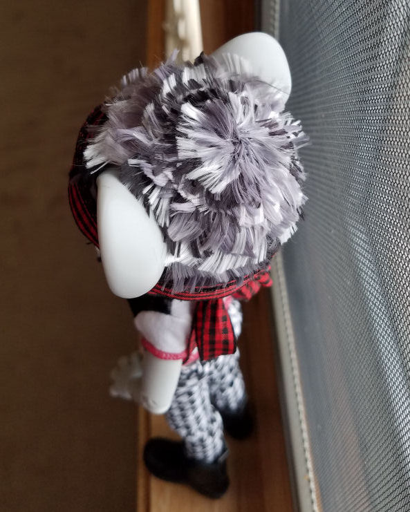 Looking down at the top of a grey Hujoo Phoebe Mouse doll head. She has a short hairstyle of choppy layers of patchy silver, steel grey, and black hair without a part. The wig closure is a slightly off center starburst of grey hair.